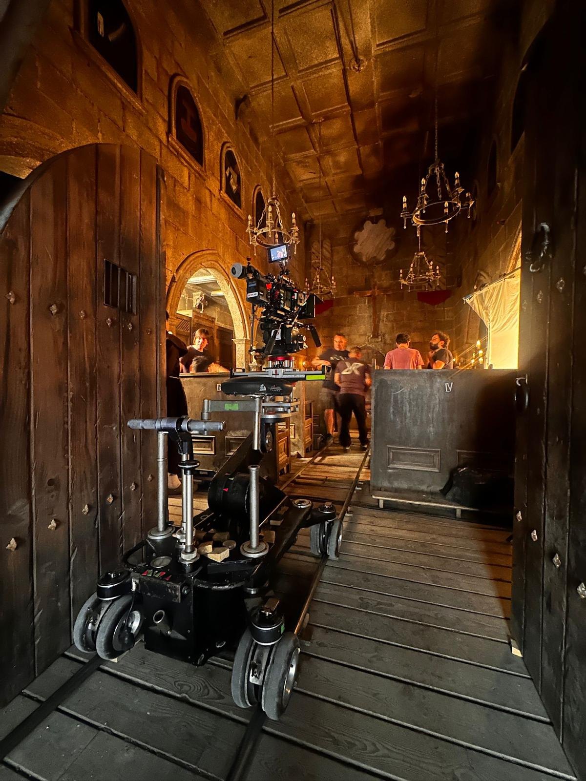 Church interior with dolly track laid, camera on the dolly and crew at work