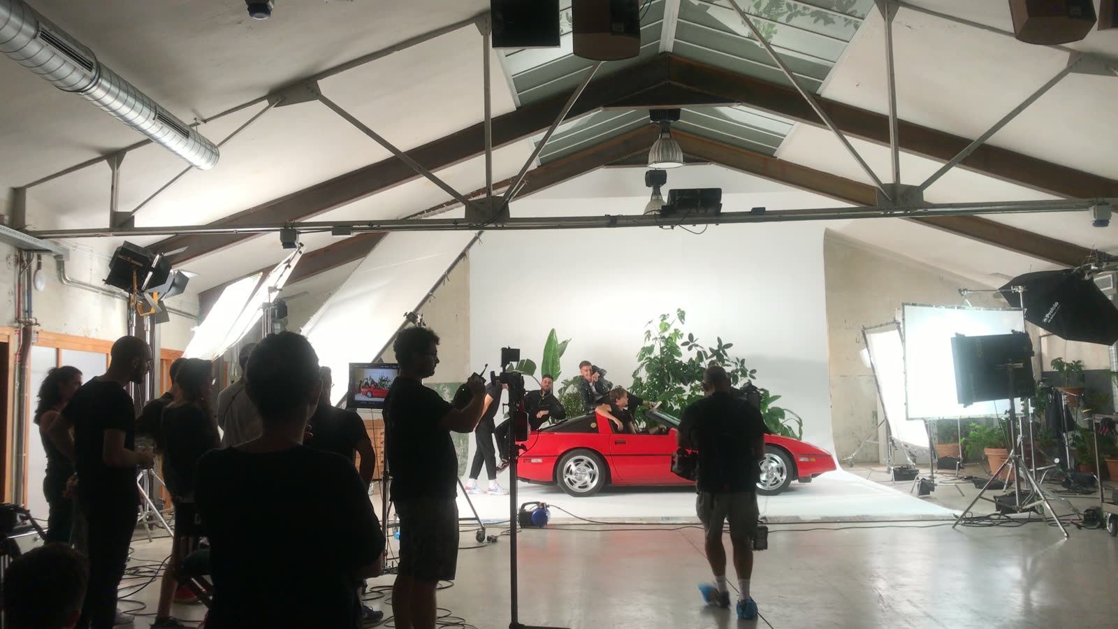 Set shoot montado bajo carpa: coche de acción, focos y equipo trabajando