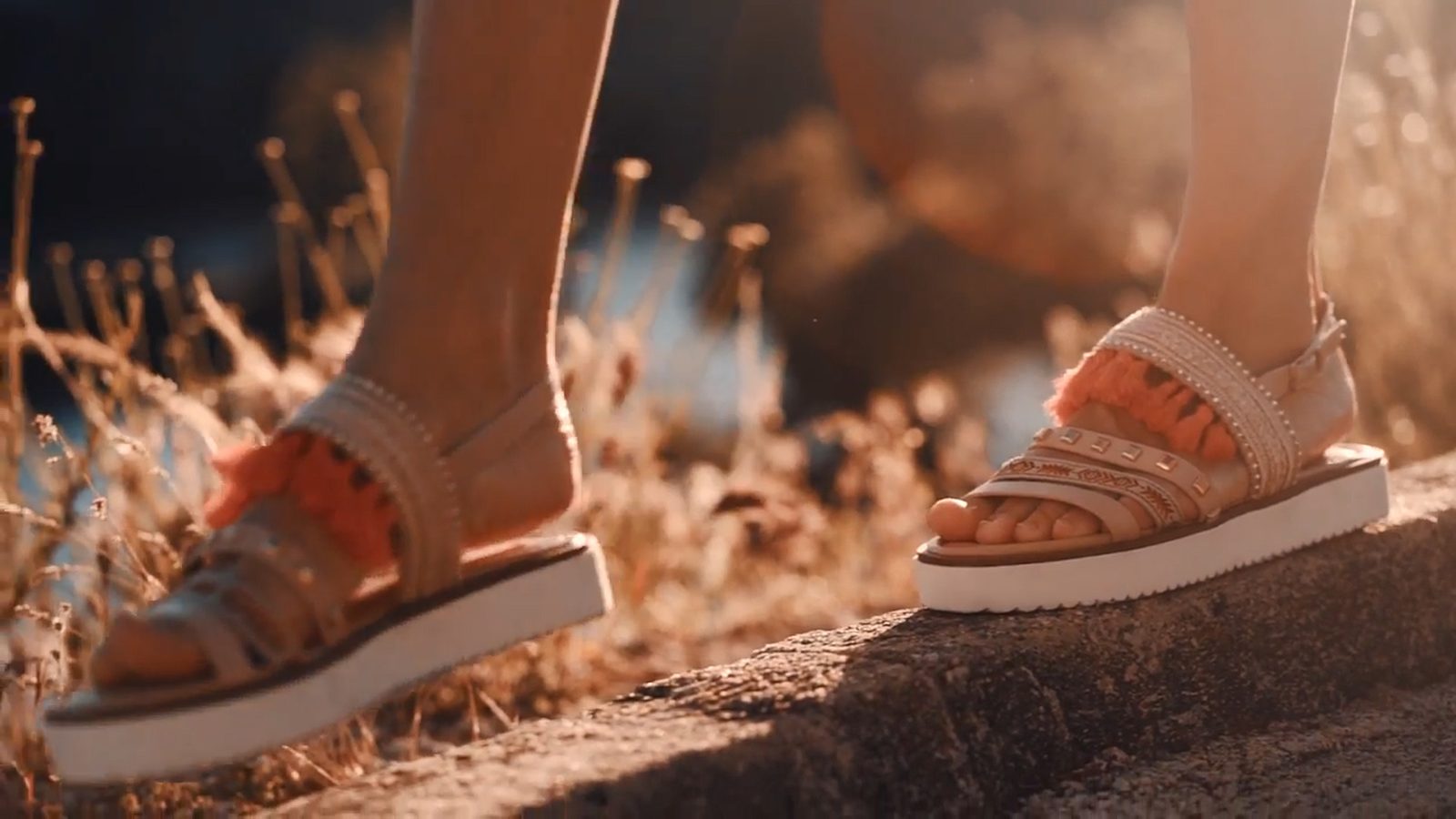Fotograma para Lola Rey: sandalias a contraluz en el campo al atardecer